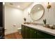 Stylish powder room features a green vanity with stone countertop, modern fixtures, and wood floors at 7175 E Camelback Rd # 401, Scottsdale, AZ 85251