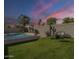 Enjoy the outdoors in this yard featuring a private pool, green lawn, string lights, and seating at 7252 E Nido Ave, Mesa, AZ 85209