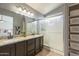 Bathroom with double sinks, granite countertops, tiled floor, glass enclosed shower, and built in storage at 7252 E Nido Ave, Mesa, AZ 85209