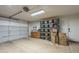 Spacious garage with ample storage, built-in cabinets, and a roll-up door at 7252 E Nido Ave, Mesa, AZ 85209