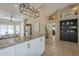 Modern eat-in kitchen with large island, granite countertops, stainless steel refrigerator, and stylish light fixture at 7252 E Nido Ave, Mesa, AZ 85209