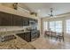 Bright eat-in kitchen boasts a dining table, granite countertops, stainless steel appliances, and tile flooring at 7252 E Nido Ave, Mesa, AZ 85209