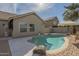 Backyard with a sparkling pool, patio, and lush tropical landscaping at 7252 E Nido Ave, Mesa, AZ 85209