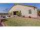 Rear exterior view of home showcasing an extended patio, desert landscaping, pool, and manicured lawn at 9455 W Melinda Ln, Peoria, AZ 85382