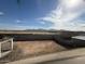 View of the backyard, showcasing dirt ground, neighborhood fencing and mountain views in the distance at 9613 W Parkway Dr, Tolleson, AZ 85353