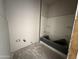 Unfinished bathroom displays a new bathtub/shower installed against bare walls, awaiting completion at 9613 W Parkway Dr, Tolleson, AZ 85353