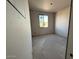 Unfinished bedroom space with bare walls, concrete floor and a window overlooking an outdoor scene at 9613 W Parkway Dr, Tolleson, AZ 85353