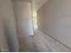 Unfinished hallway displays bare walls, concrete floor, and doorway at the end with a glimpse of outdoor view at 9613 W Parkway Dr, Tolleson, AZ 85353