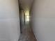 Unfinished hallway showcasing its length, bare walls, and floor, offering a view towards a bright window at the end at 9613 W Parkway Dr, Tolleson, AZ 85353