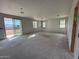 Large unfinished living room featuring multiple windows and a sliding glass door for ample natural light and outdoor access at 9613 W Parkway Dr, Tolleson, AZ 85353