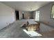 Unfinished large living area showing bare walls, a concrete floor, and boxes stacked in the middle of the room at 9613 W Parkway Dr, Tolleson, AZ 85353