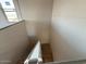 View looking down at unfinished wooden stairs with natural light at 9613 W Parkway Dr, Tolleson, AZ 85353