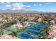 Stunning aerial view of community tennis courts, lush landscaping, and mountain views in the distance at 9705 E Mountain View Rd # 1143, Scottsdale, AZ 85258