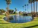 Scenic pond with a fountain, surrounded by lush landscaping and tall palm trees at 9705 E Mountain View Rd # 1143, Scottsdale, AZ 85258