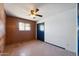 This bedroom features a ceiling fan, a window and closet with a wood paneled wall at 1153 E 12Th St, Casa Grande, AZ 85122