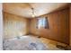 This bedroom features a ceiling fan, wood paneled walls, and a window with curtains at 1153 E 12Th St, Casa Grande, AZ 85122