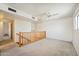 Open bonus room featuring a ceiling fan and wood railing leading to a hallway at 1153 E 12Th St, Casa Grande, AZ 85122