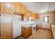 Well-lit kitchen featuring wooden cabinetry, white appliances, and ample storage space at 1153 E 12Th St, Casa Grande, AZ 85122