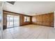 Bright living room with tile flooring, wood-paneled walls, and sliding glass doors at 1153 E 12Th St, Casa Grande, AZ 85122