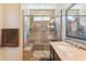 Bright bathroom showcasing a walk-in shower with decorative tile and a vanity with a granite countertop at 12734 W Crestvale Dr, Peoria, AZ 85383