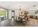 Bright dining room with wood floors, pendant lighting, and a view into the modern kitchen at 12734 W Crestvale Dr, Peoria, AZ 85383