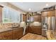 Well-lit kitchen with stainless steel appliances, wood cabinetry, and stone backsplash at 12734 W Crestvale Dr, Peoria, AZ 85383