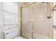 Cozy bathroom featuring a toilet and shower with a frosted glass door, complemented by natural light from the window at 12826 S 40Th Pl, Phoenix, AZ 85044