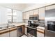 A well-lit kitchen features stainless steel appliances, white cabinets, and a window providing natural light at 12826 S 40Th Pl, Phoenix, AZ 85044