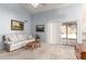 Bright living room featuring neutral walls, carpeted floors, a sliding glass door, and a comfortable sofa at 12826 S 40Th Pl, Phoenix, AZ 85044