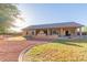 Expansive backyard view with a patio, outdoor fireplace, lush lawn, and manicured landscaping at 13007 W Tuckey Ct, Glendale, AZ 85307