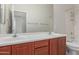 Bathroom features a double vanity, modern fixtures, and a framed mirror with access to the bathtub at 13007 W Tuckey Ct, Glendale, AZ 85307