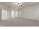 Bedroom featuring neutral carpet, ceiling fan, and archway leading to bathroom at 13007 W Tuckey Ct, Glendale, AZ 85307