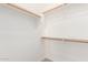 Bright white walk-in closet featuring wood rods and shelves for optimal storage and organization at 13007 W Tuckey Ct, Glendale, AZ 85307