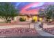 Beautiful single-story home featuring desert landscaping, stone accents, and inviting curb appeal at sunset at 13007 W Tuckey Ct, Glendale, AZ 85307