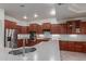 Kitchen showcasing dark cabinets, modern appliances, light countertops, and tiled floors at 13007 W Tuckey Ct, Glendale, AZ 85307