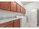 Functional laundry room with ample cabinetry, counter space, and modern washer and dryer units at 13007 W Tuckey Ct, Glendale, AZ 85307