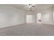 Main bedroom featuring carpet, ceiling fan, double door entry, and neutral color palette at 13007 W Tuckey Ct, Glendale, AZ 85307