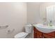Powder room with pedestal sink, round mirror, and dark wood cabinets at 13007 W Tuckey Ct, Glendale, AZ 85307