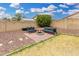 Backyard oasis featuring a fire pit with seating, manicured landscaping, privacy fence, and a grassy area at 13308 W Acapulco Ln, Surprise, AZ 85379