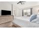 Main bedroom with neutral decor, large window, ceiling fan, and dresser at 13308 W Acapulco Ln, Surprise, AZ 85379