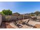 Backyard featuring a fire pit area, privacy landscaping, and a shade awning for outdoor enjoyment at 13545 W Caribbean Ln, Surprise, AZ 85379