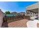 View of a backyard featuring a rock area, wooden fence and covered patio perfect for outdoor entertaining at 13545 W Caribbean Ln, Surprise, AZ 85379