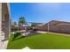 Well-manicured backyard with lush artificial turf and a cozy lounge area, perfect for outdoor entertaining at 13545 W Caribbean Ln, Surprise, AZ 85379