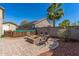 Backyard with a stone patio area, a charming fire pit, and well-placed landscaping, perfect for relaxing at 13545 W Caribbean Ln, Surprise, AZ 85379