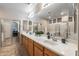 Large bathroom featuring double sinks, spacious countertop, and a glass-enclosed shower at 13545 W Caribbean Ln, Surprise, AZ 85379