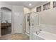 Bathroom featuring tiled floors, large soaking tub with chrome fixtures, and a glass shower at 13545 W Caribbean Ln, Surprise, AZ 85379