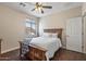 Bedroom with wood floors, ceiling fan, and a window providing natural light at 13545 W Caribbean Ln, Surprise, AZ 85379