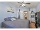 Bedroom featuring a ceiling fan, wood-look flooring, and nearby bathroom and utility access at 13545 W Caribbean Ln, Surprise, AZ 85379