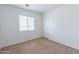 This bedroom features neutral carpet, white walls, and a window for natural light at 1361 W Roosevelt Ave, Coolidge, AZ 85128