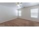 Bright bedroom with neutral carpet, a ceiling fan, and natural light from two windows at 1361 W Roosevelt Ave, Coolidge, AZ 85128